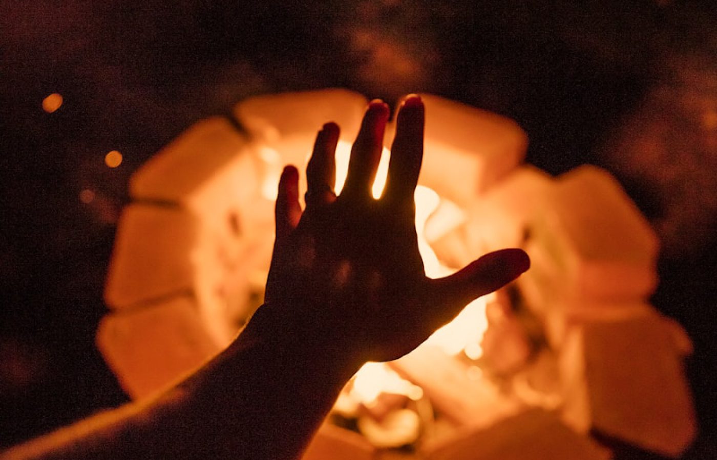 Photo by Explore with Joshua person putting left hand near bonfire